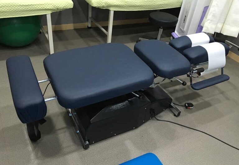 A chiropractor gently examining an adult patient's spine in a bright, clean clinic setting.