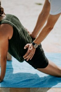 Adult performing a controlled bridge exercise on a mat with knees bent and hips raised.