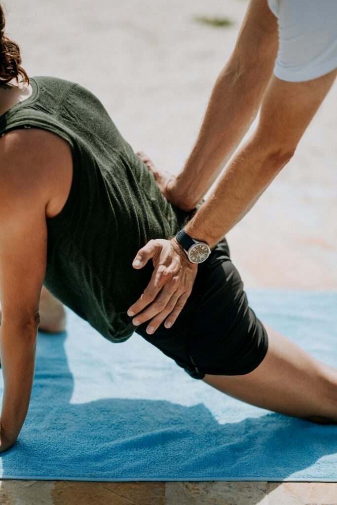 Adult performing a controlled bridge exercise on a mat with knees bent and hips raised.